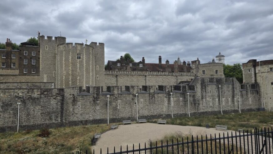 A view of the Tower of London showing the drained moat in the foreground